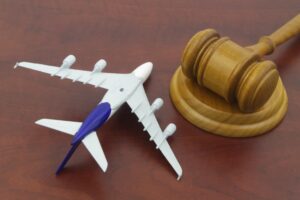 A broken airplane fuselage with a judge's gavel resting on top, symbolizing the pursuit of justice after a tragedy.