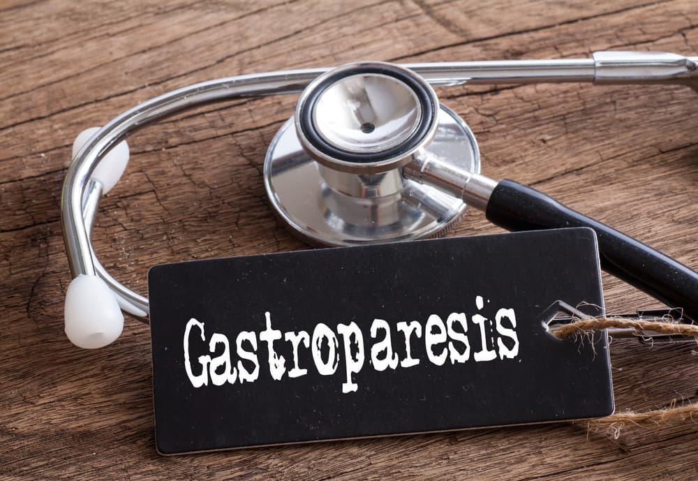 Stethoscope on Wooden Surface with 'Gastroparesis' Word, Representing a Medical Concept.